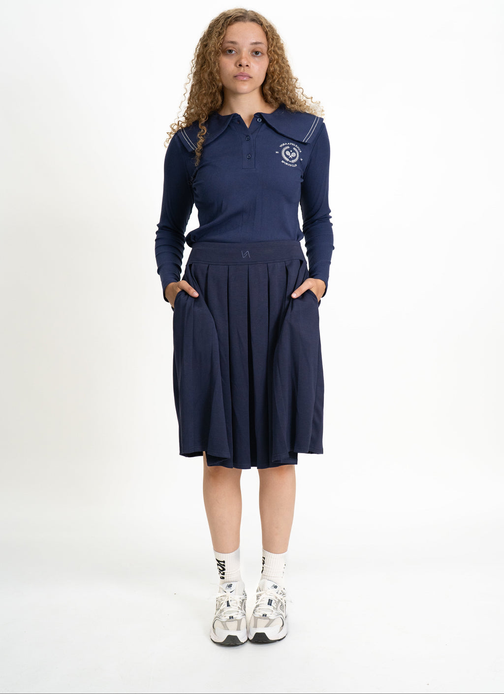 Person wearing a navy blue outfit with a logo on a white background